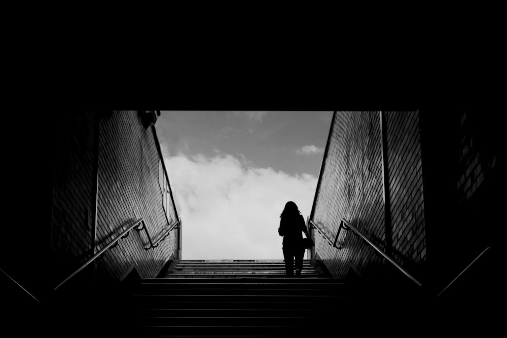 silhouette of man walking on wooden bridge