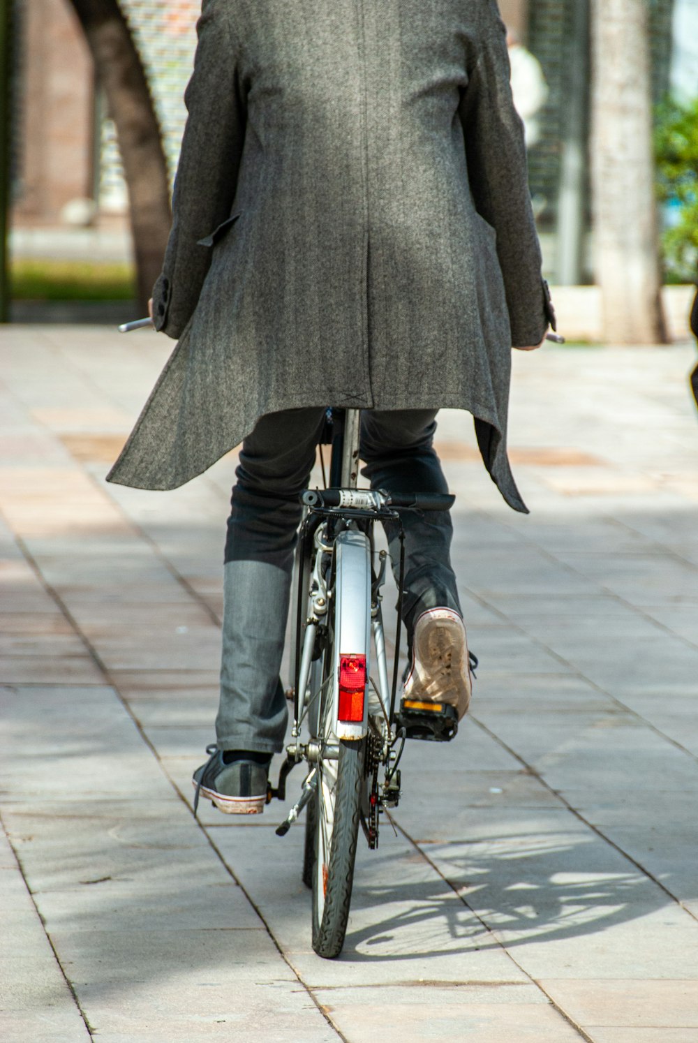 person in black coat riding on black bicycle