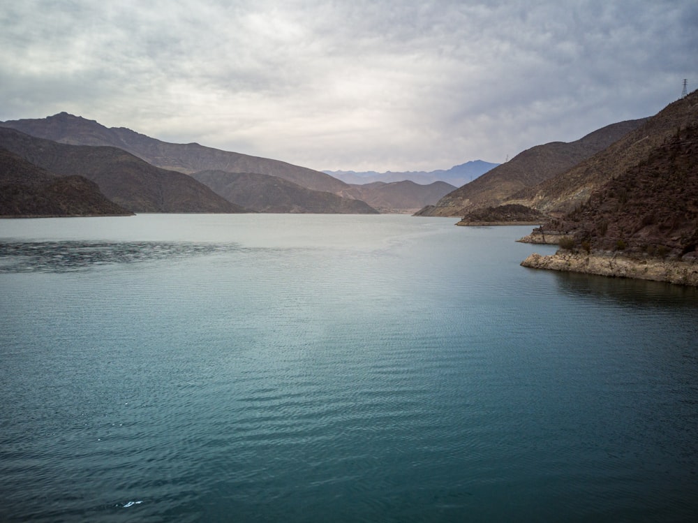 green lake near mountain during daytime