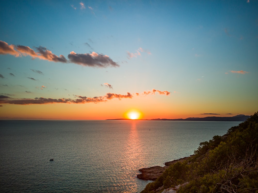 Cuerpo de agua bajo el cielo azul durante la puesta del sol