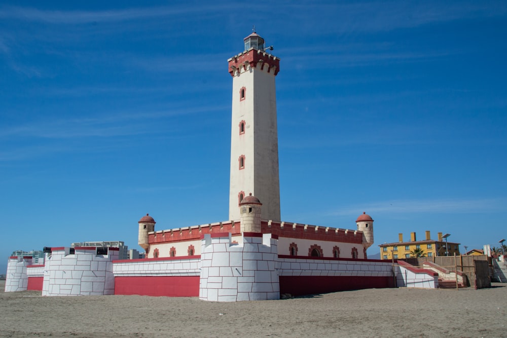 Phare en béton blanc et brun sous le ciel bleu pendant la journée