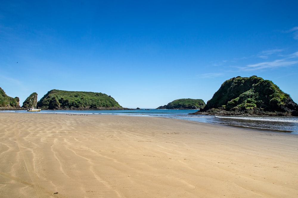 blue sea near green mountain under blue sky during daytime