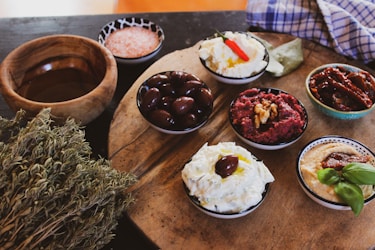 A rustic wooden board displaying an assortment of freshly baked breads and dips.
