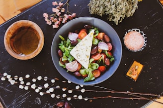 A person preparing a Mediterranean diet salad with olive oil and herbs.