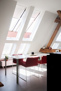 Loft conversions design with window and white and brown wooden table and chairs