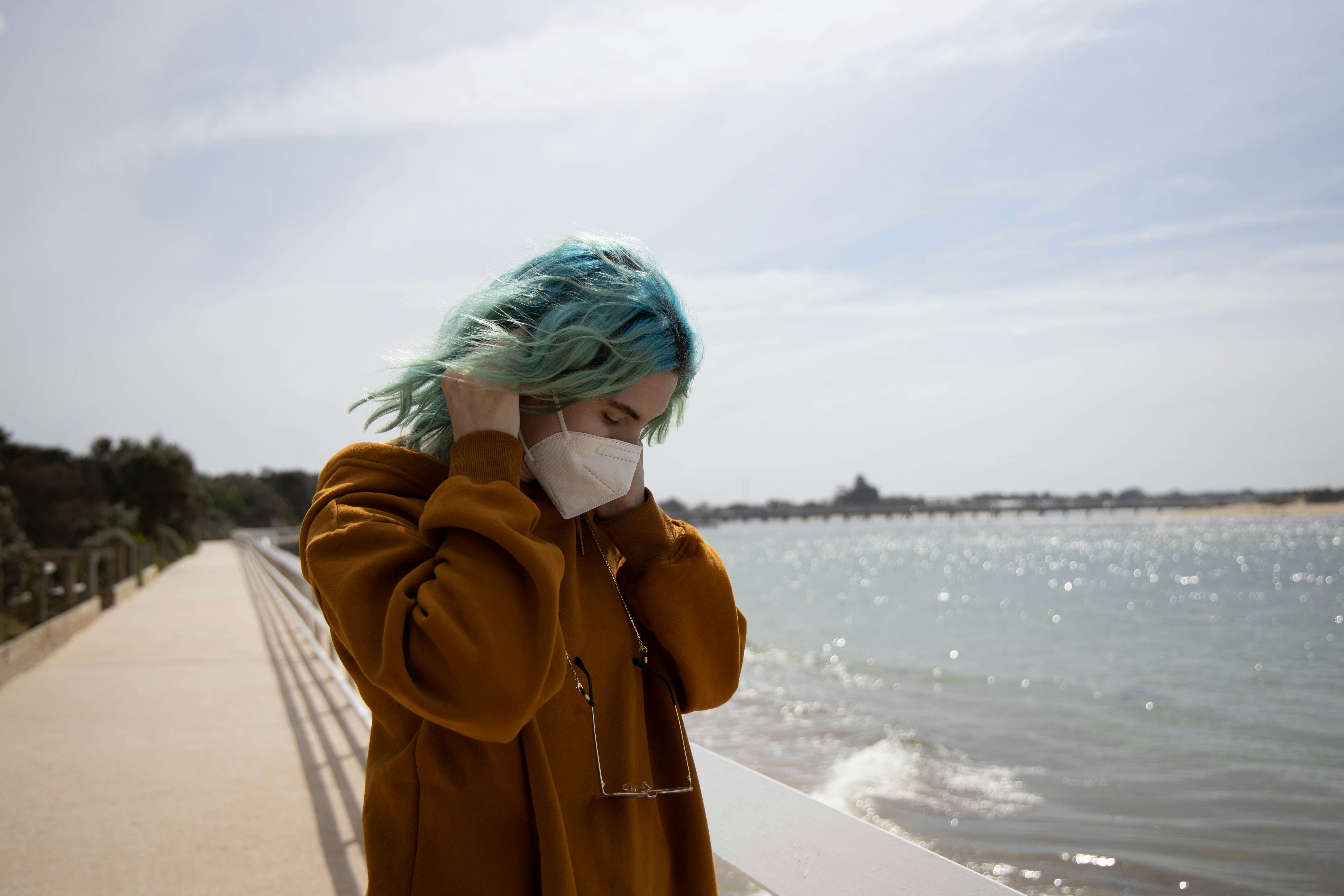 woman in brown coat standing on beach during daytime