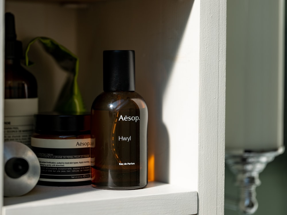 black and brown plastic bottle on white wooden shelf