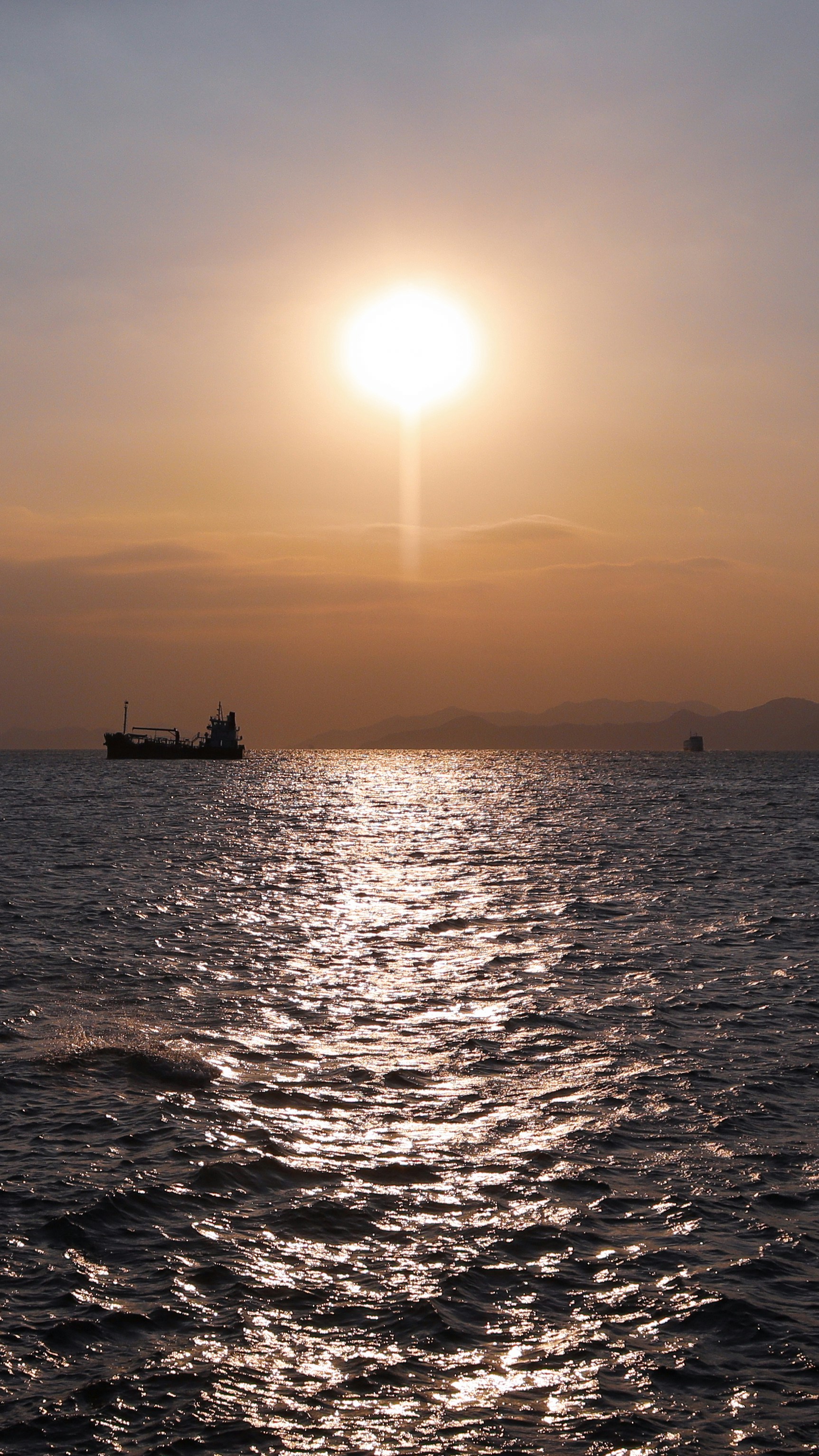 silhouette of boat on sea during sunset
