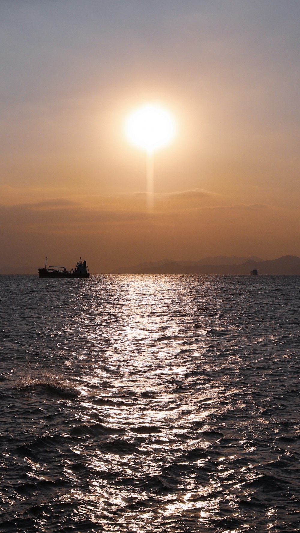 silhouette of boat on sea during sunset