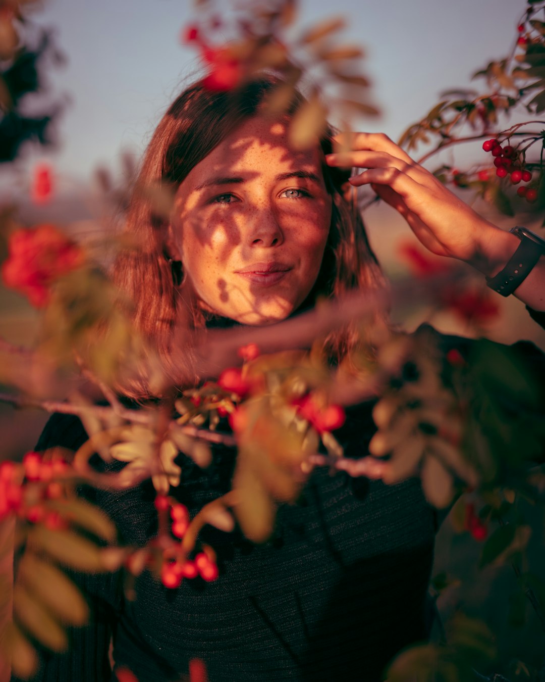 woman in black long sleeve shirt holding red flowers