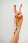 person with blue green and orange tattoo on right hand