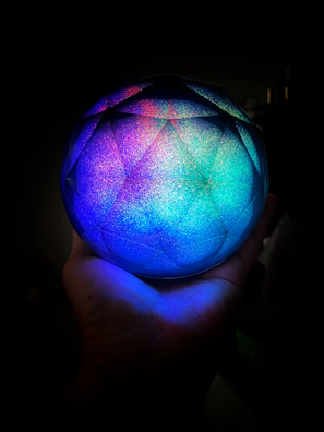 A mystical hand holding a radiant astrological globe with constellations shining brightly.