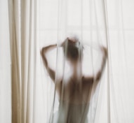 woman in white tank top raising her hands