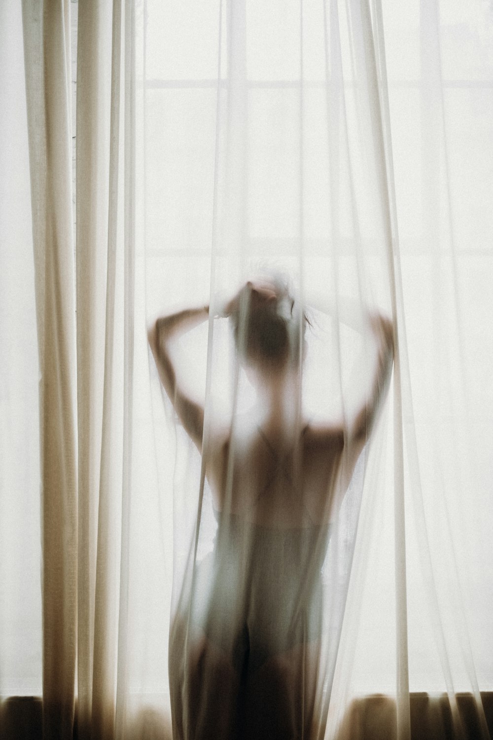 woman in white tank top raising her hands