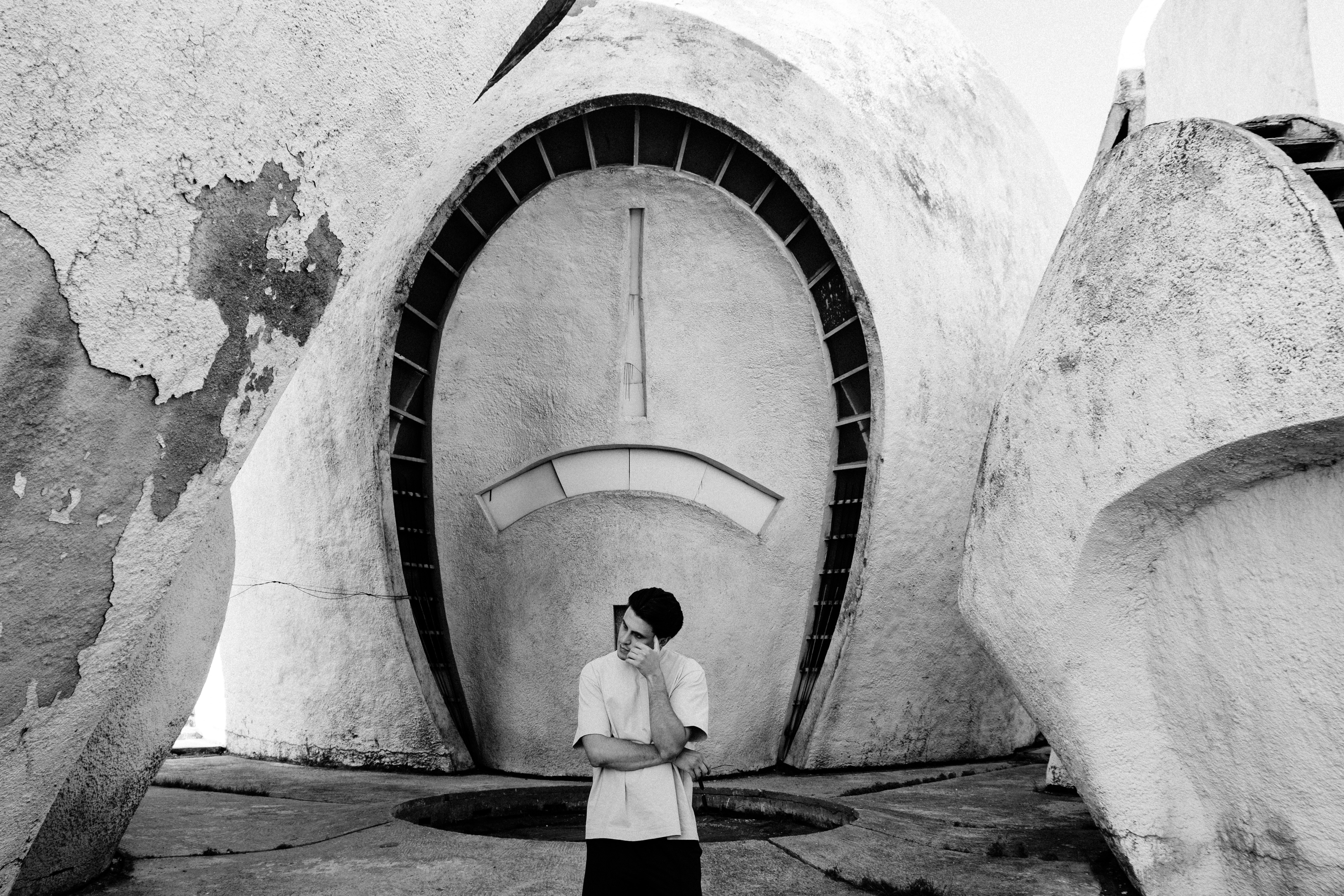 man in white dress shirt standing in front of tunnel