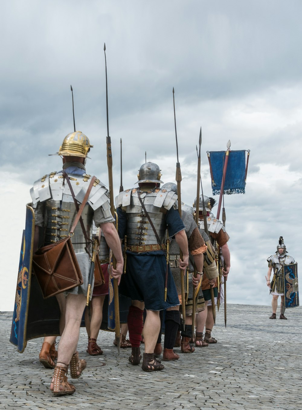 Gruppe von Männern in brauner und grüner Tarnuniform, die tagsüber auf grauem Sand stehen