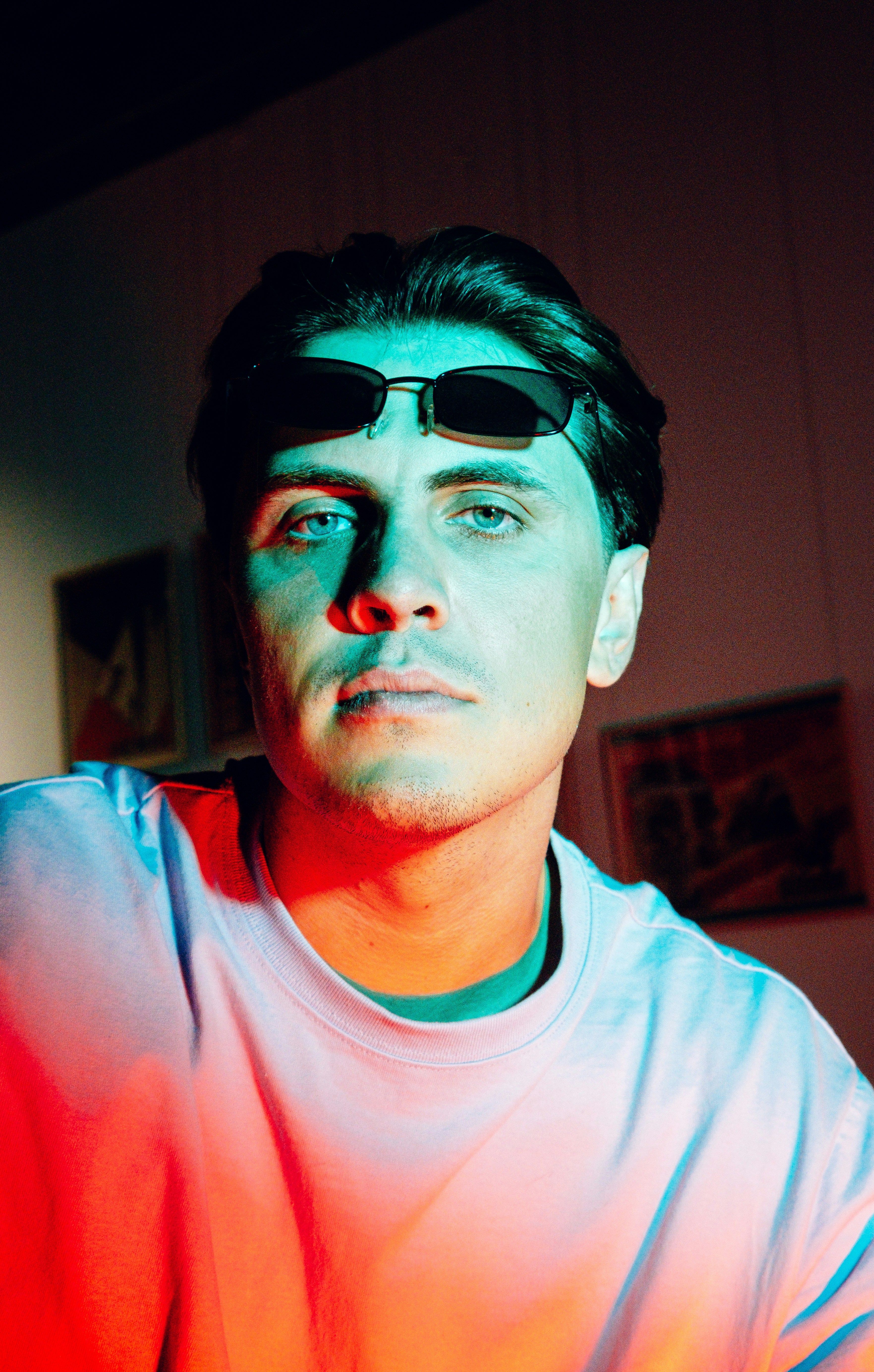 man in teal crew neck shirt wearing black framed eyeglasses