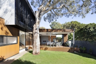brown and white wooden house near green trees during daytime