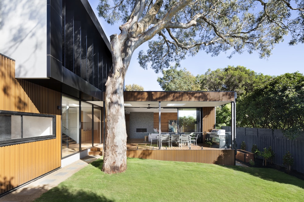 Maison en bois marron et blanc près des arbres verts pendant la journée