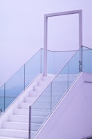 A minimalist staircase with glass balustrades and floating steps.