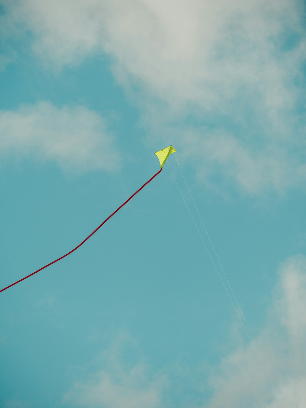 cerf-volant en papier jaune volant sur le ciel bleu pendant la journée