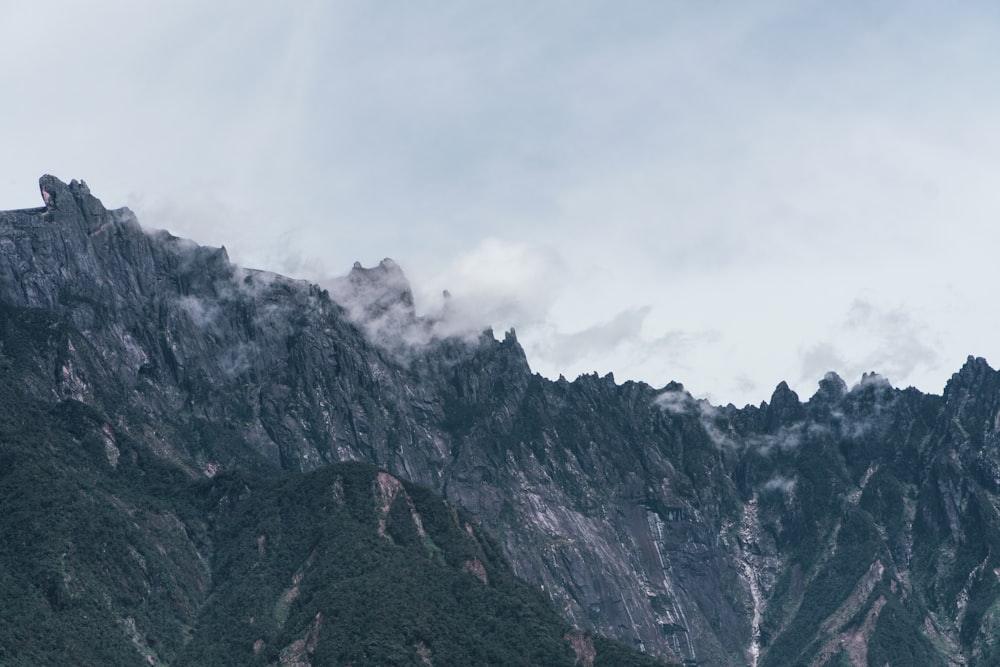 gray and green mountain under white clouds during daytime