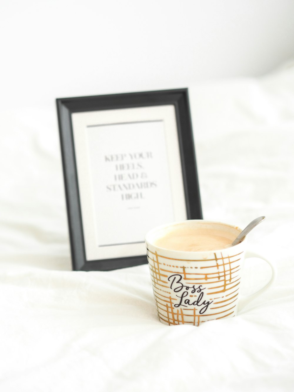 black wooden photo frame beside white and brown ceramic mug