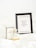A framed print with the quote, 'Keep your heels, head & standards high,' resting on a light-colored surface. Beside it, there is a Chanel No. 5 perfume bottle and its packaging, giving a sense of elegance and sophistication.