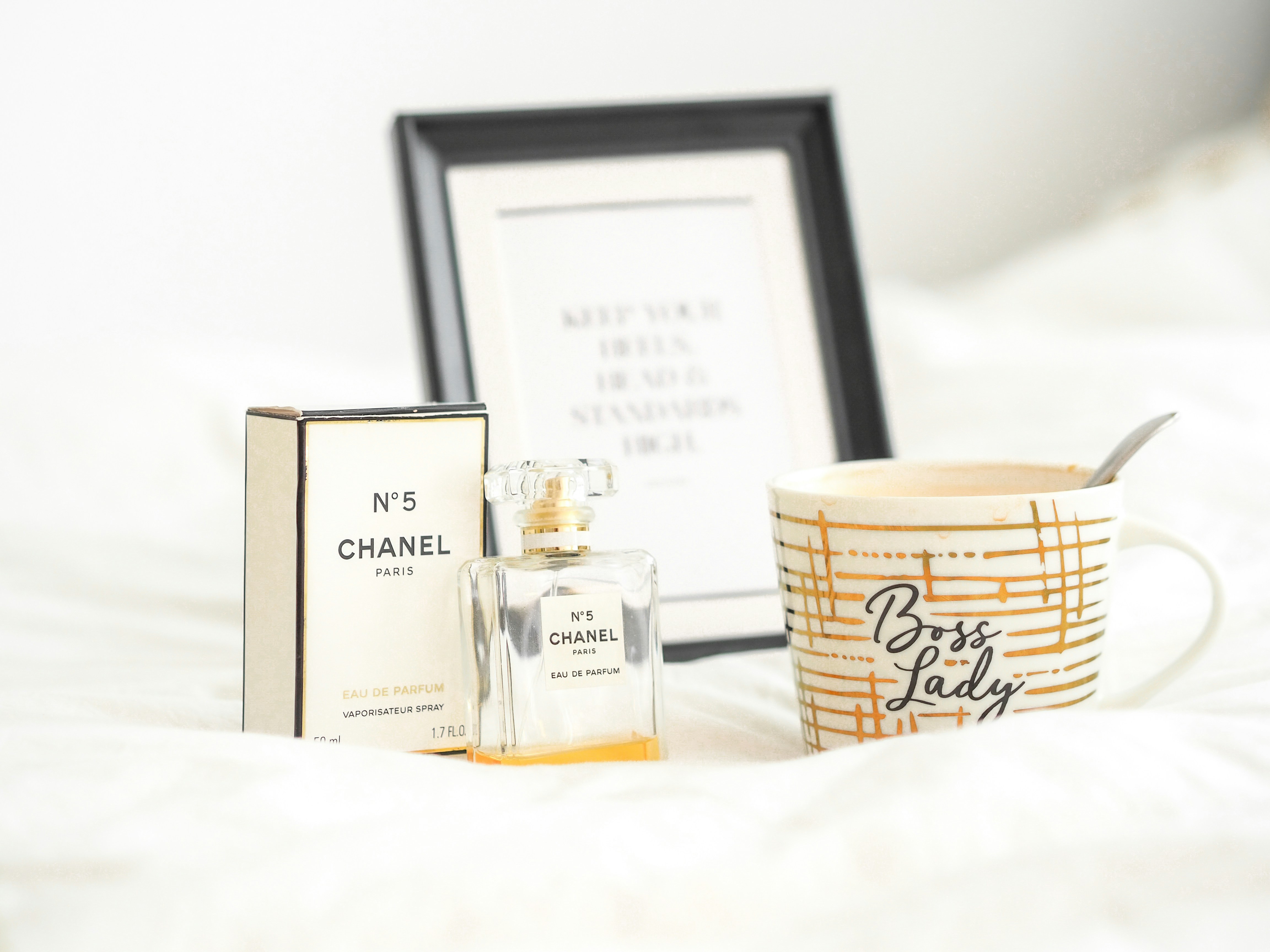 white and gold perfume bottle beside white box