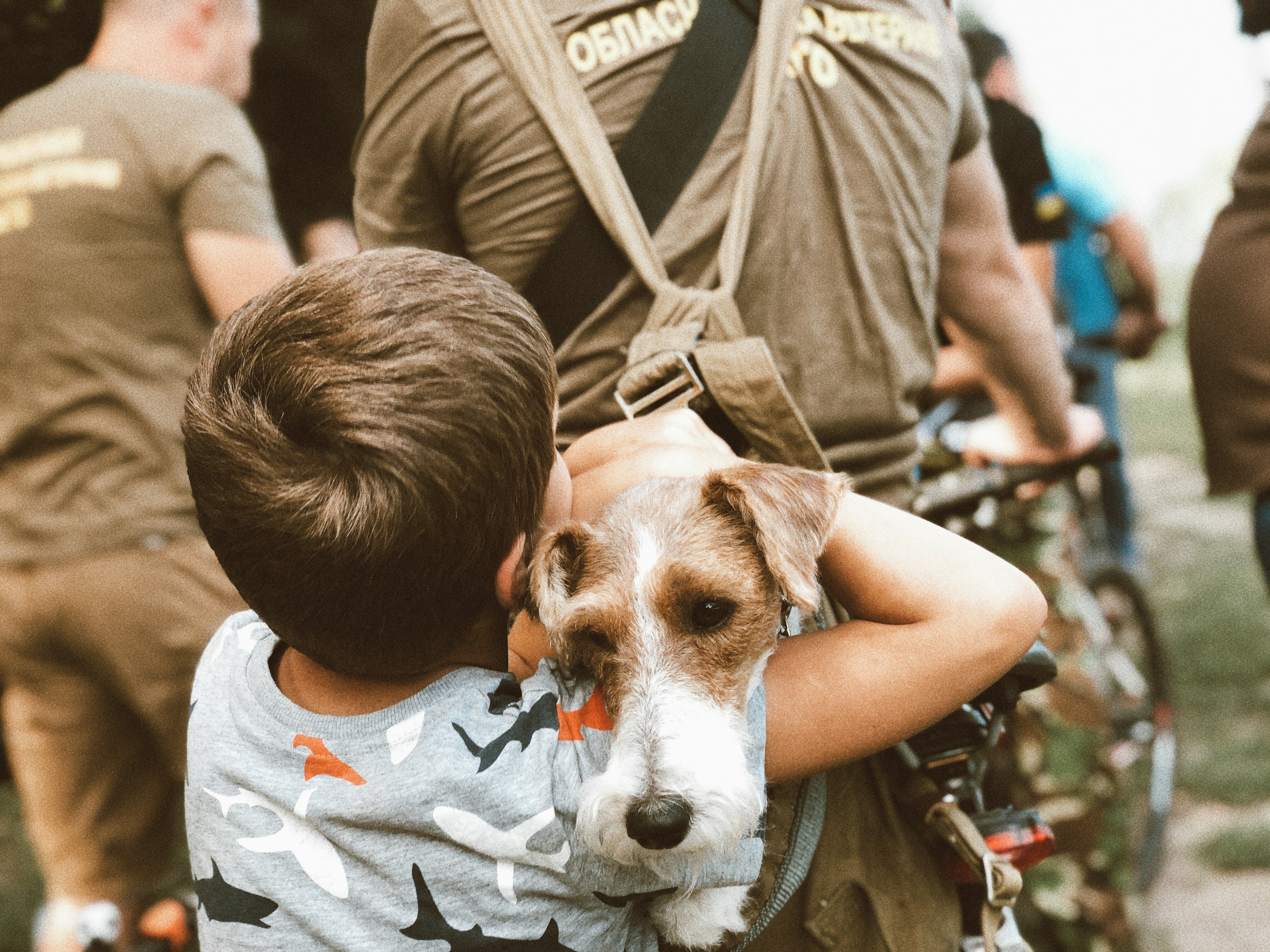 man in gray crew neck t-shirt carrying brown and white short coated dog
