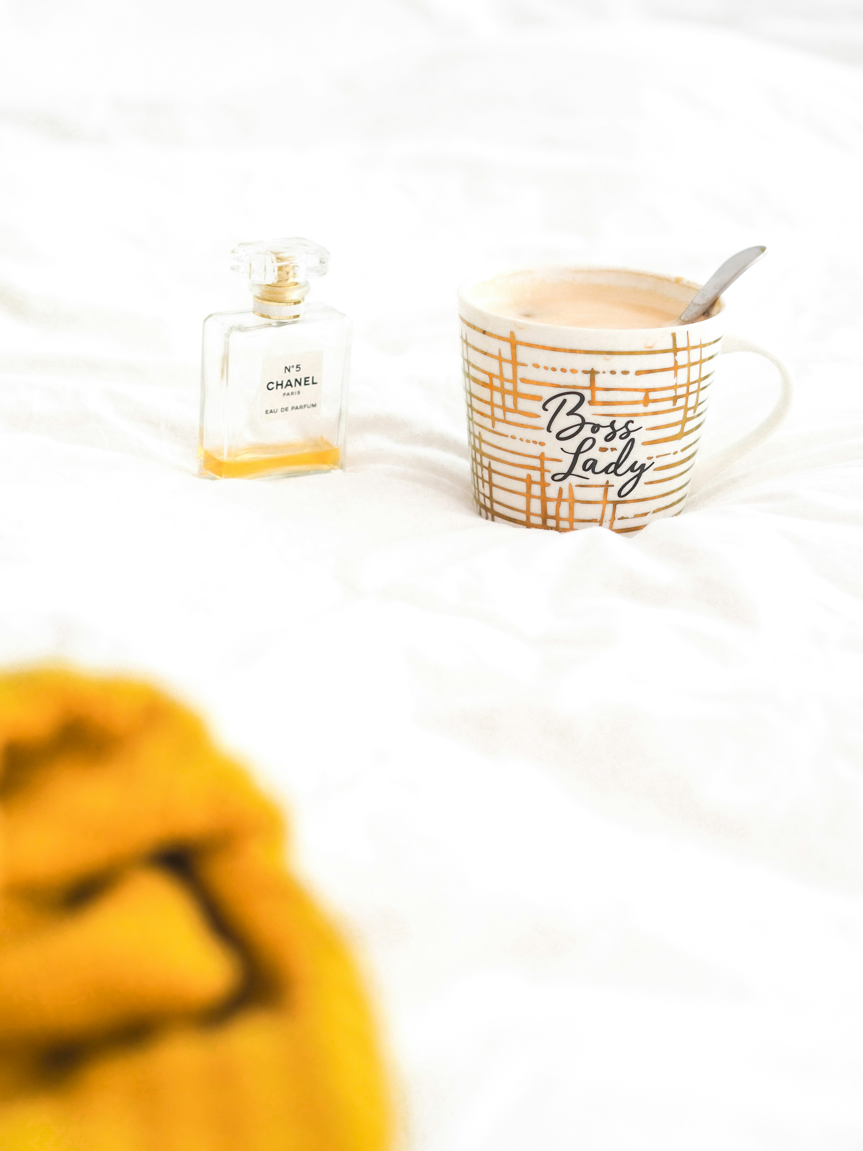 clear glass bottle beside white ceramic mug