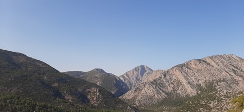 A serene landscape featuring mountains under a clear sky.