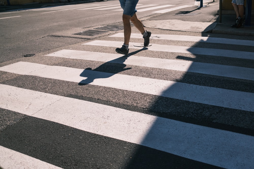 person in white shorts walking on pedestrian lane during daytime