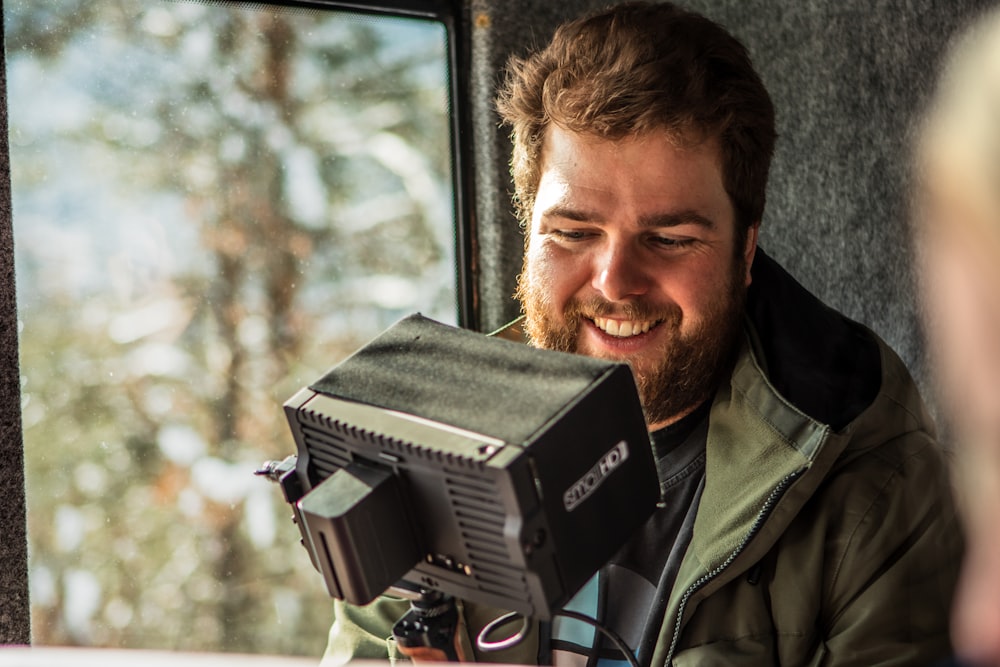 a man holding a camera in front of a window