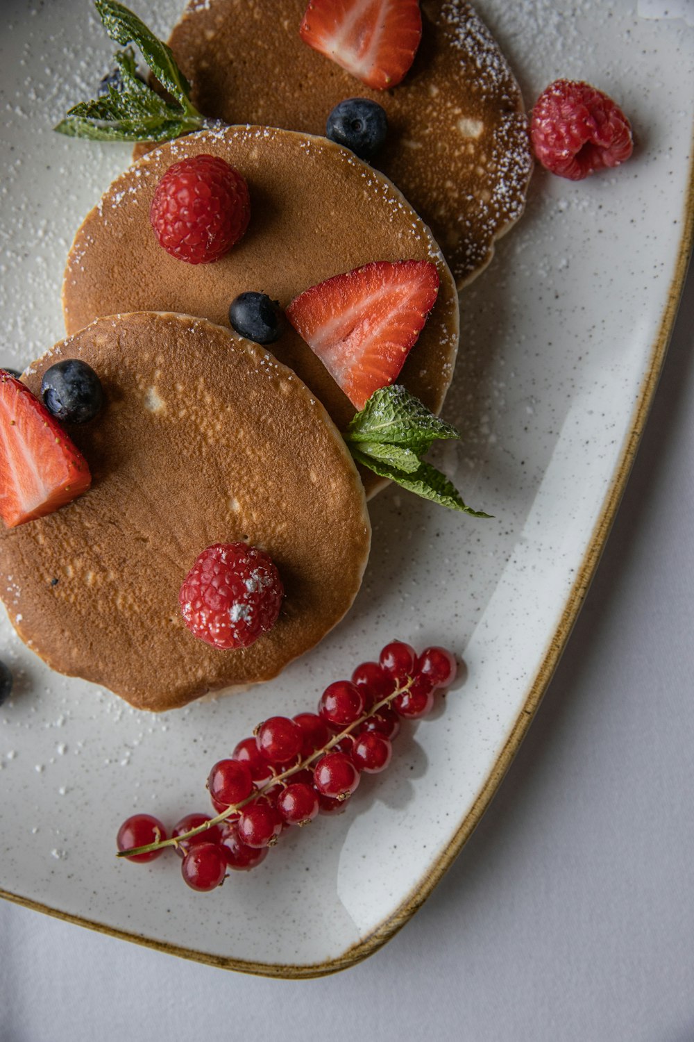 a white plate topped with pancakes covered in fruit