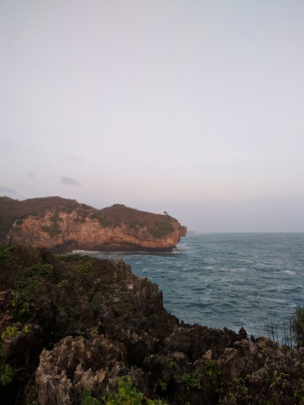 brown rock formation near body of water during daytime