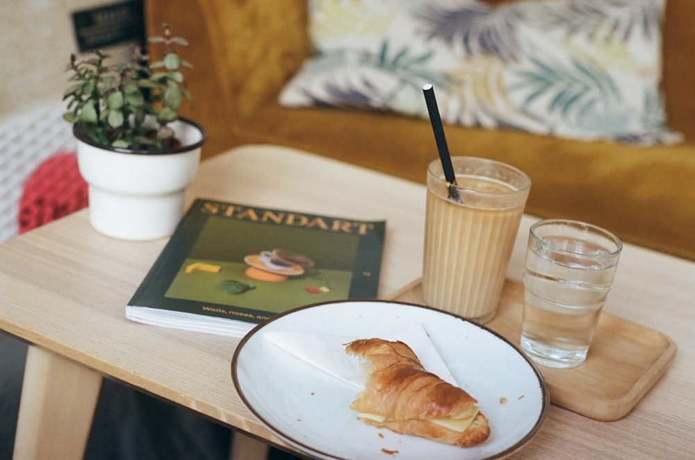 bread on white ceramic plate beside drinking glass