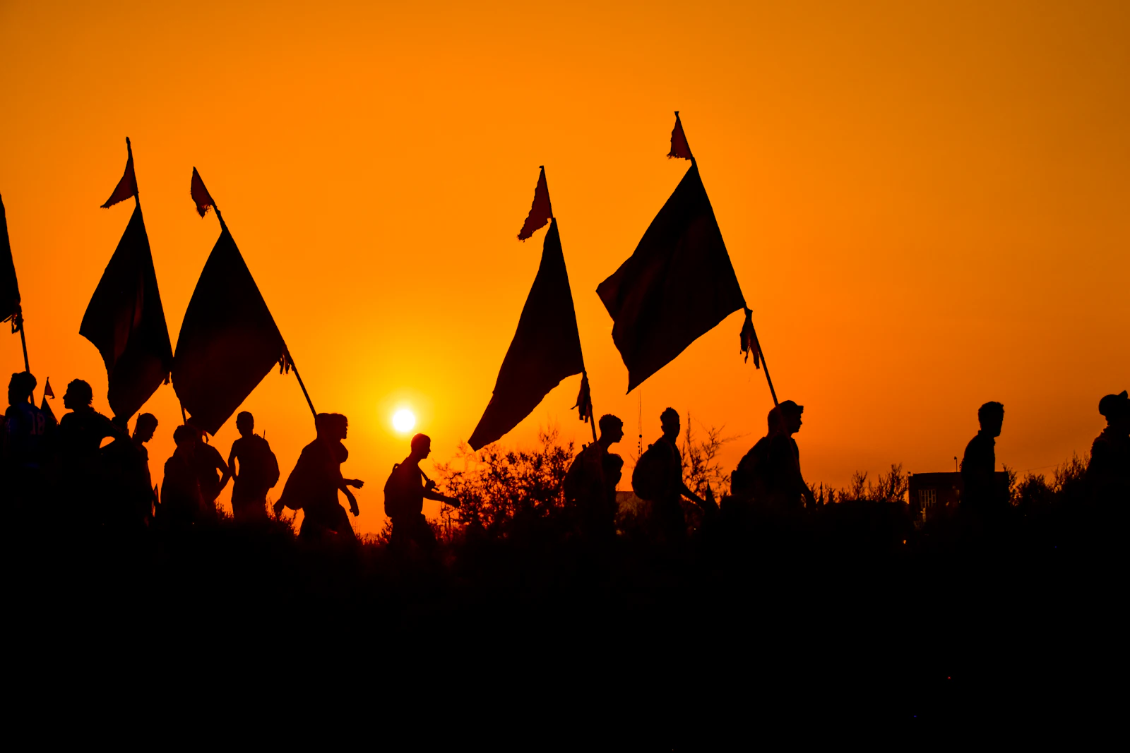 Pilgrims with banners walking into the sunset
