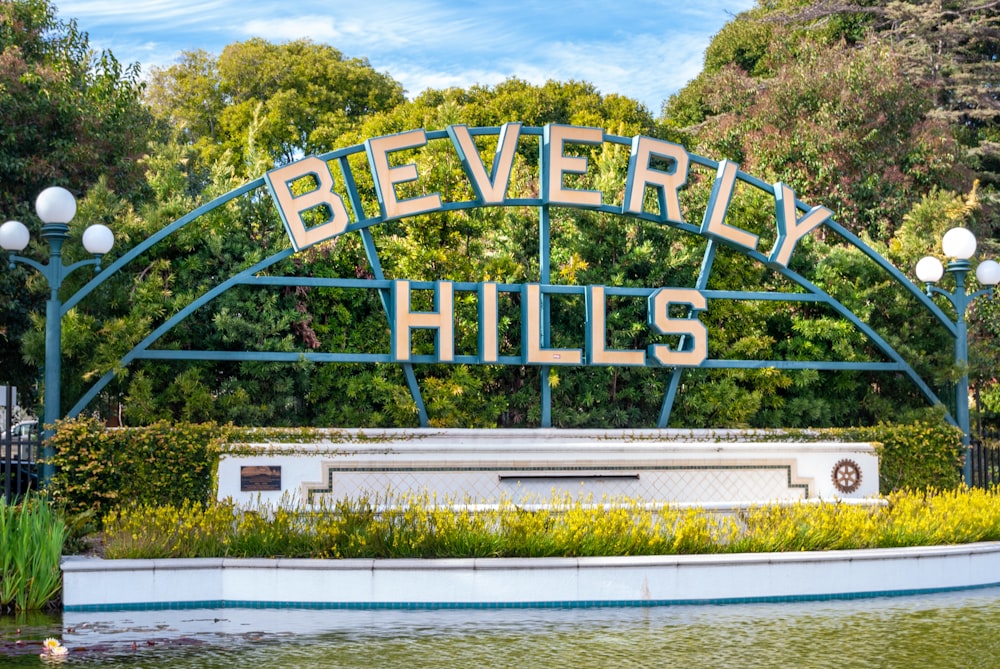 Un cartello che dice Beverly Hills davanti a uno specchio d'acqua