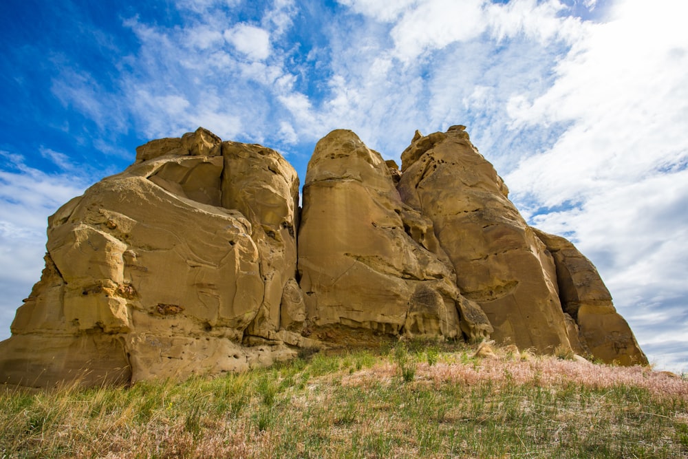 brown rock formation under blue sky and white clouds during daytime