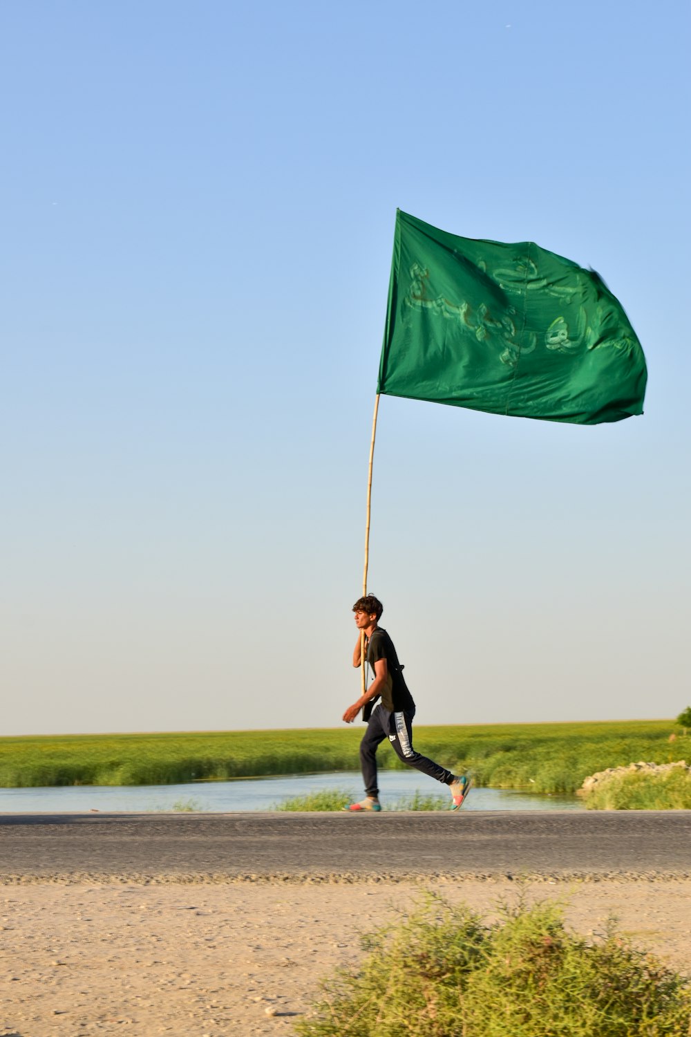 woman in black jacket and black pants holding green flag