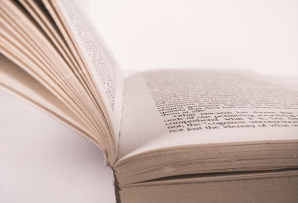 An open book with visible text on the pages, captured at an angle that highlights the thickness and texture of the pages.