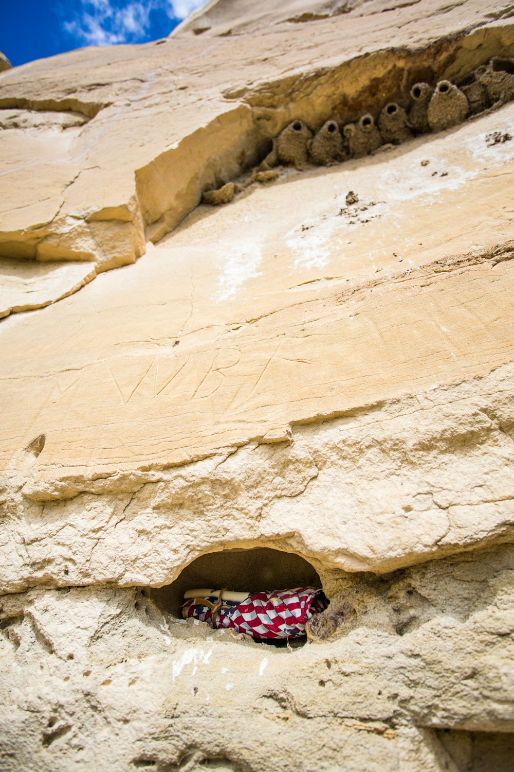 woman in black and pink floral dress sitting on brown rock