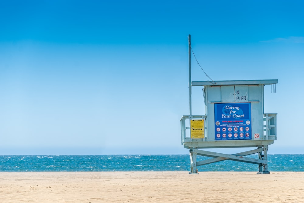 blue wooden lifeguard house on beach during daytime