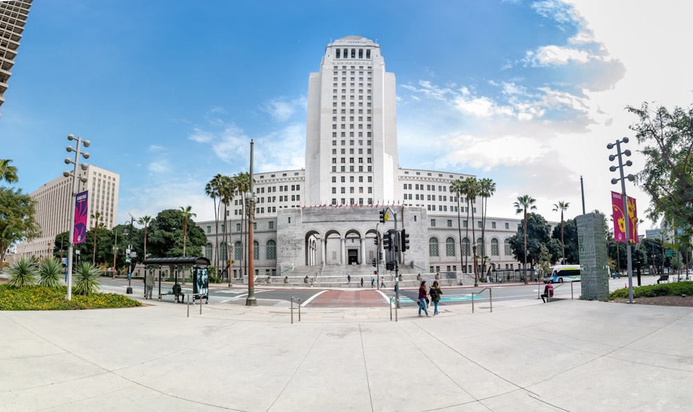 people walking on park near white concrete building during daytime