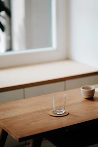 A cozy dining table set with minimalist tableware and a stylish coaster set catching the afternoon light.