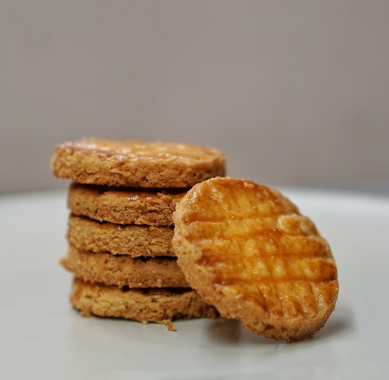 Golden butter cookies stacked on a white surface