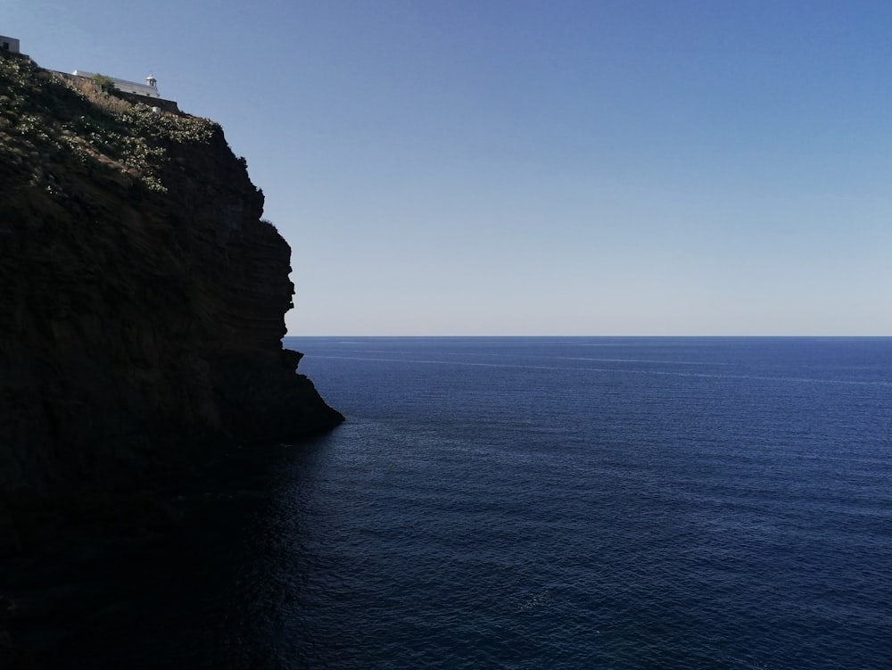 white and brown concrete building on cliff by the sea during daytime