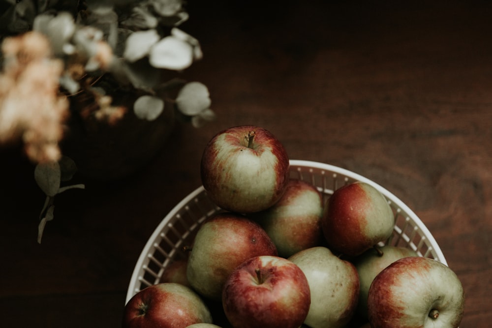 red apples on white ceramic bowl