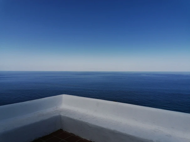 Luxurious ocean view from a penthouse balcony overlooking the calm sea.